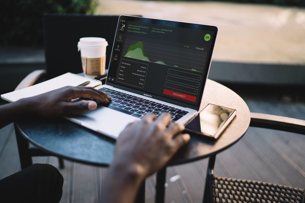 Person using IPVanish VPN on laptop at a cafe